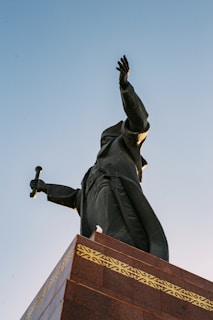 Bronze statue of a majestic historical figure standing with intricate detailing.