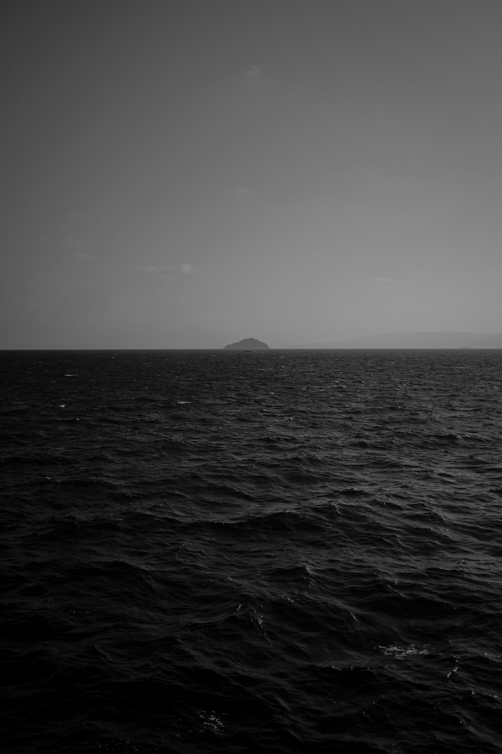 grayscale photography of body of water viewing mountain