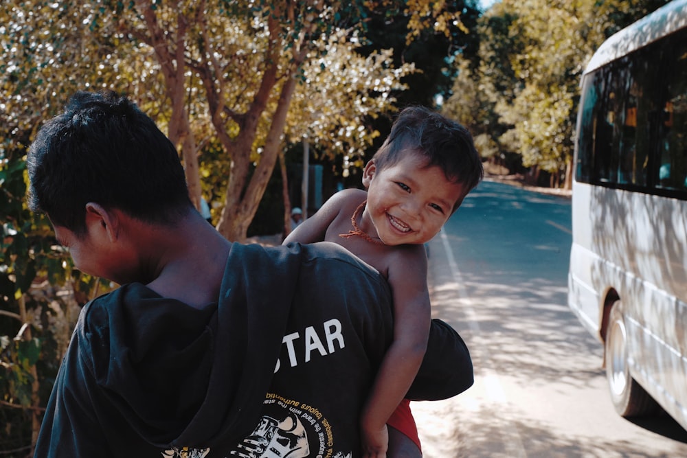 a young boy is being carried on his shoulders by a man