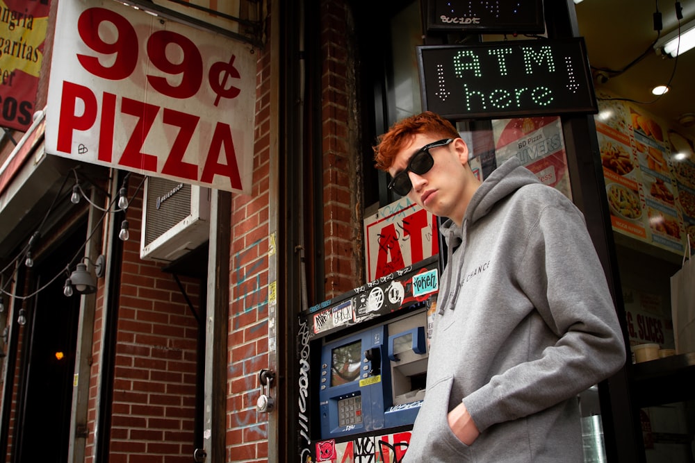 man wearing black sunglasses beside building