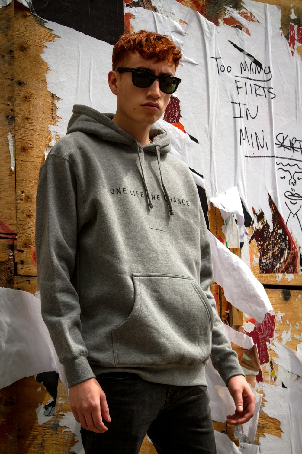 Mann mit Sonnenbrille und grauem Kapuzenpullover