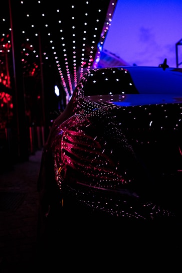 A sleek red luxury car parked against a deep blue gradient background, reflecting the vibrant and premium spirit of keys & go.
