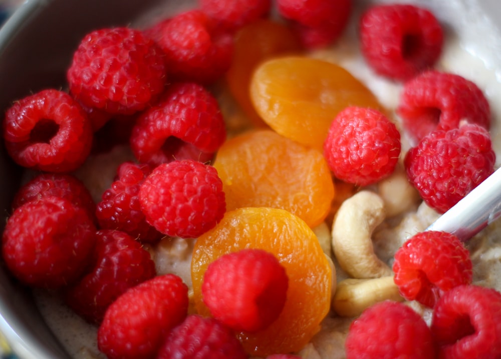 a bowl of oatmeal with fruit and cashews