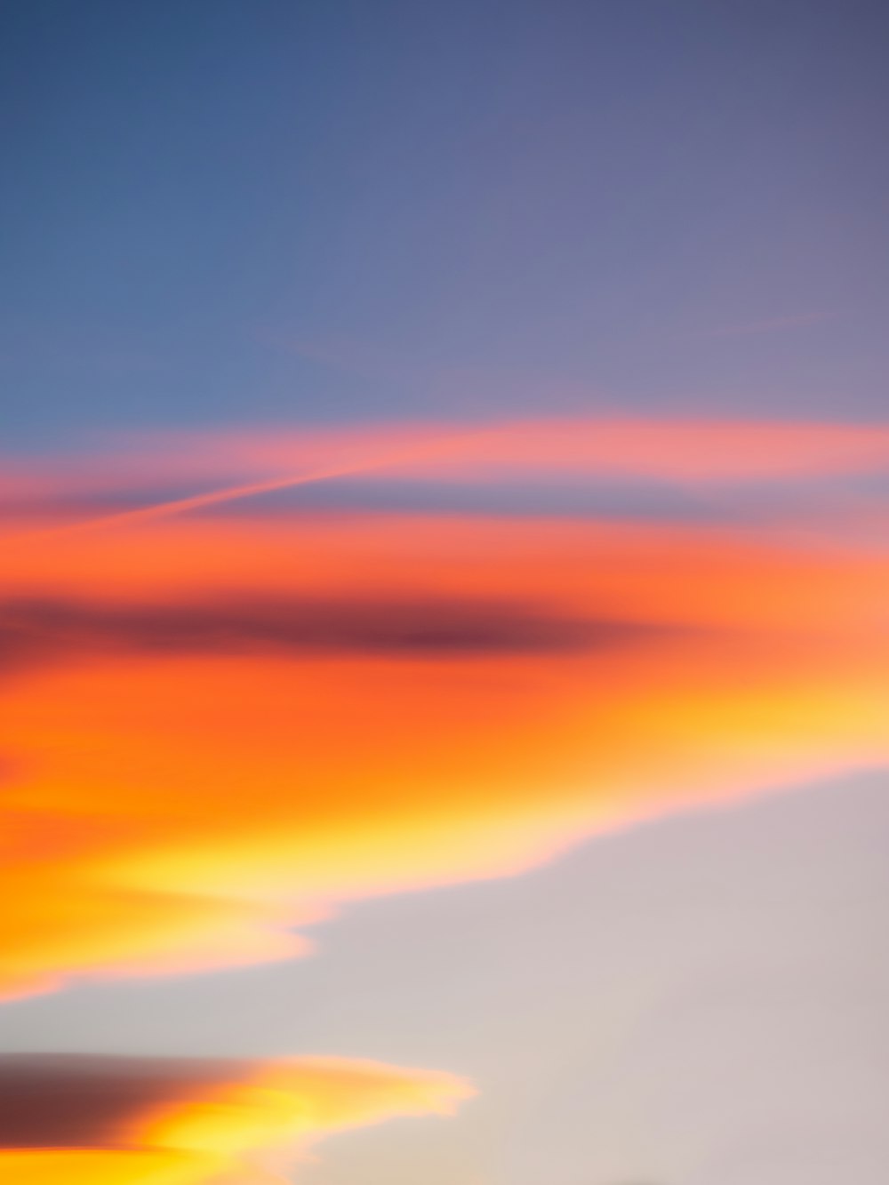 a plane flying in the sky at sunset