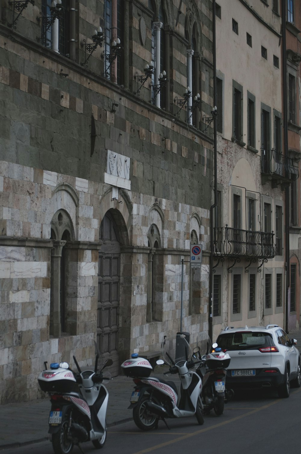 two white-and-black motor scooters near building