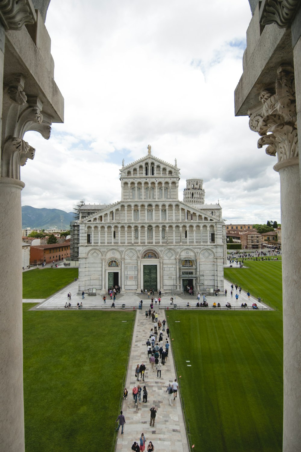 people near Piazza dei Miracoli in Italy under white and blue sky