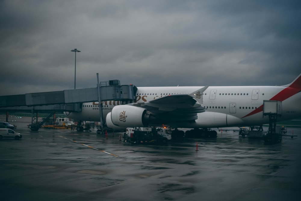 white and black airplane under cloudy sky