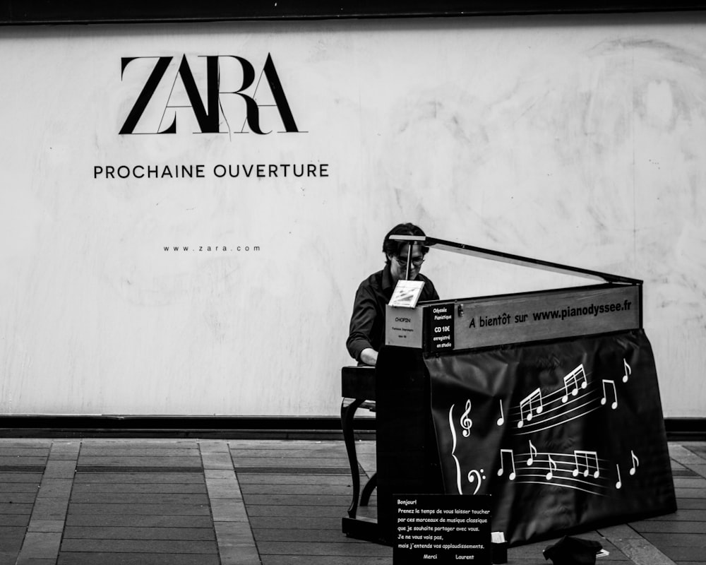 Zara Prochaine Ouverture sign near person sitting