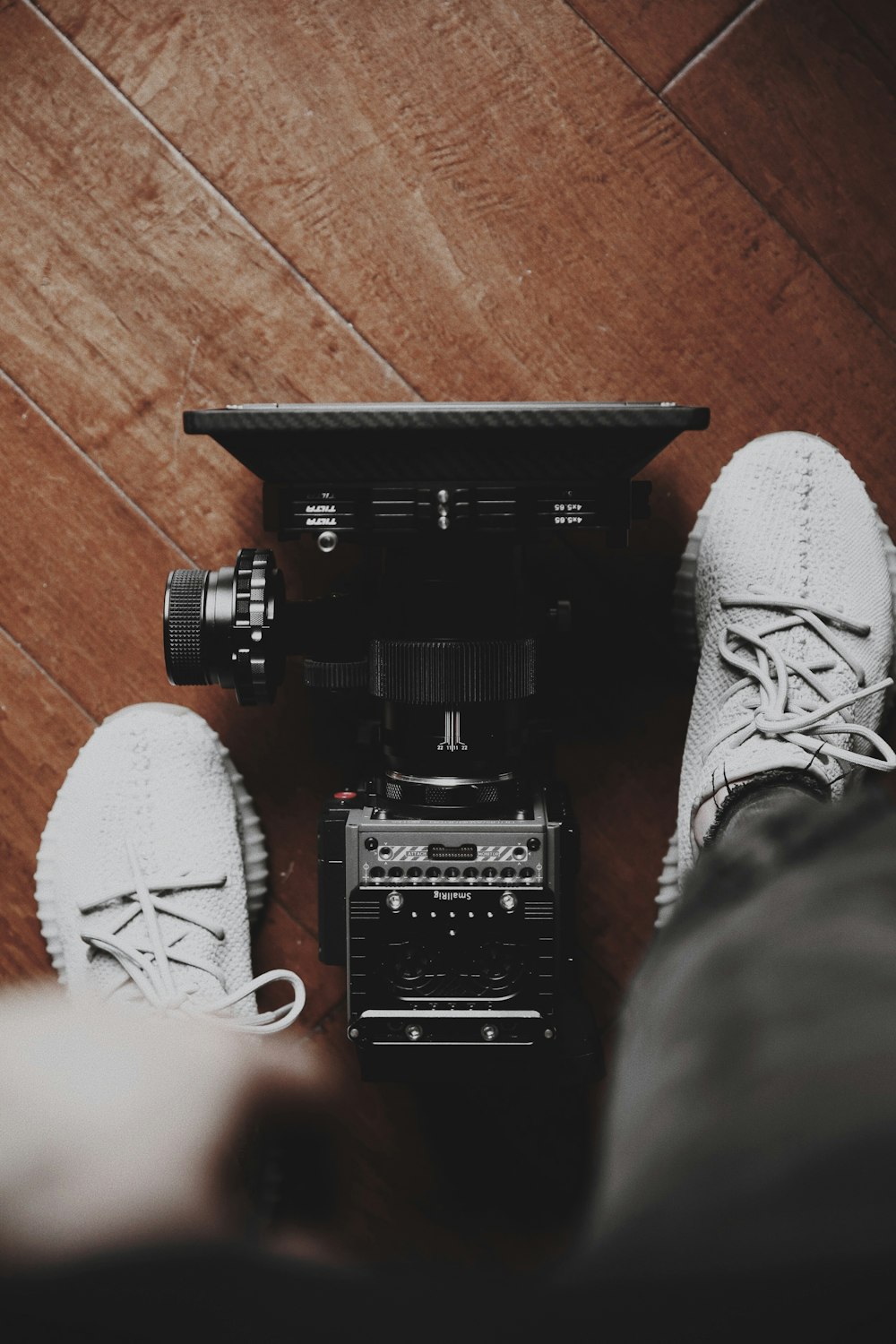 câmera de estúdio preta e prateada entre sapatos
