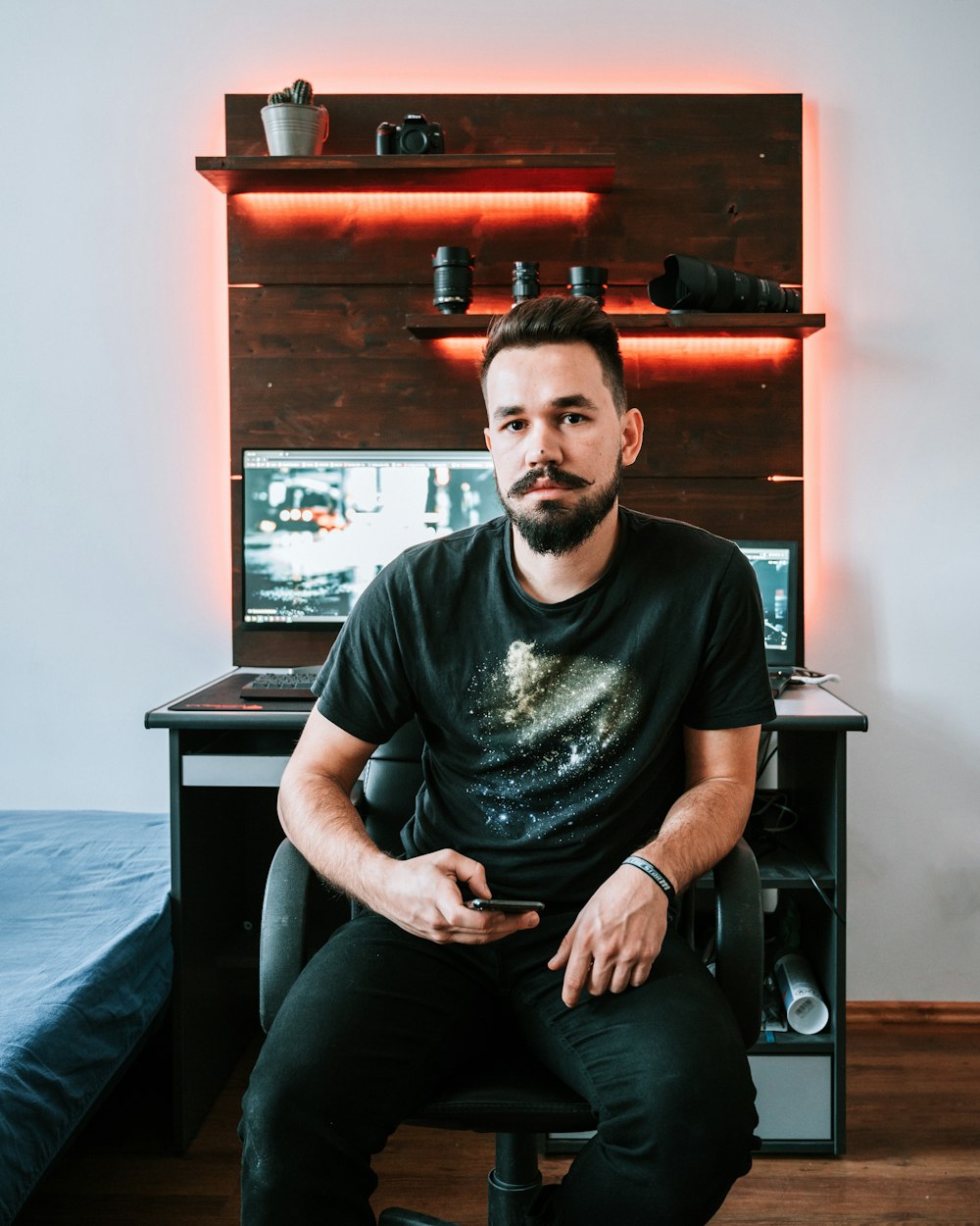 man sitting on armchair holding smartphone