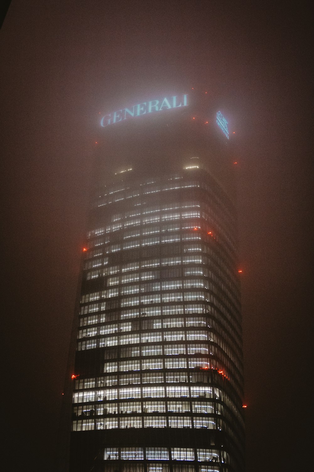 a tall building with a neon sign on top of it