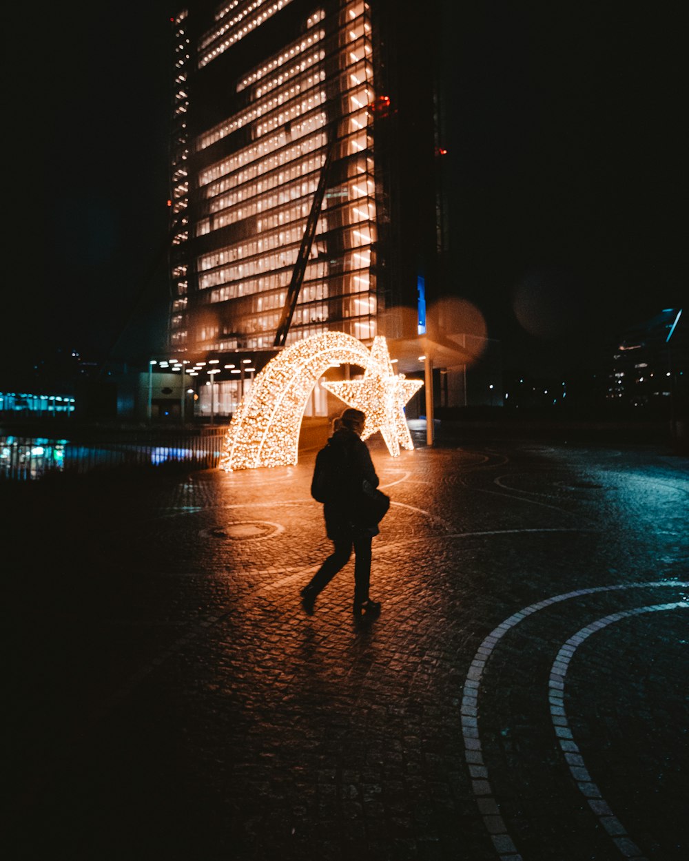 a person standing in front of a building at night