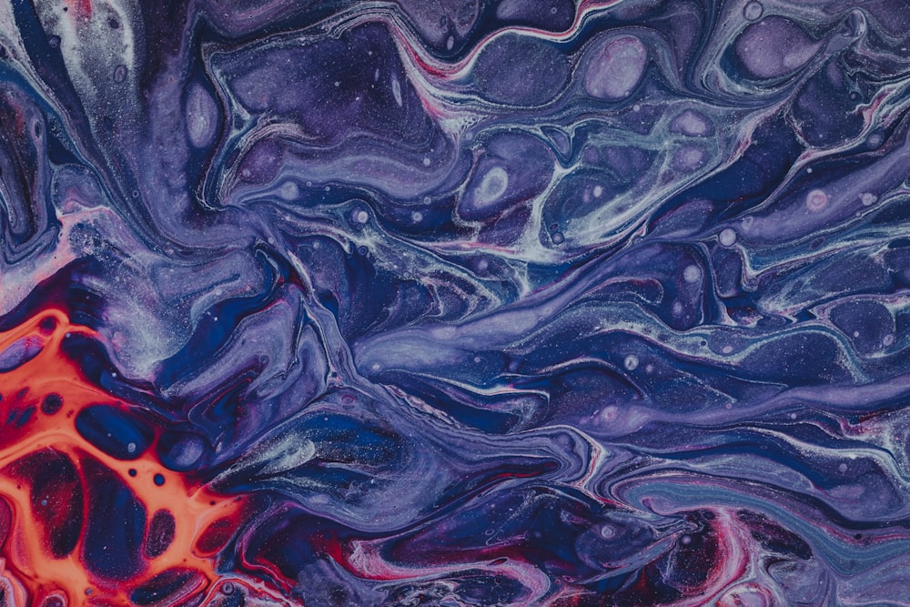 a close up of an abstract painting with red and blue colors
