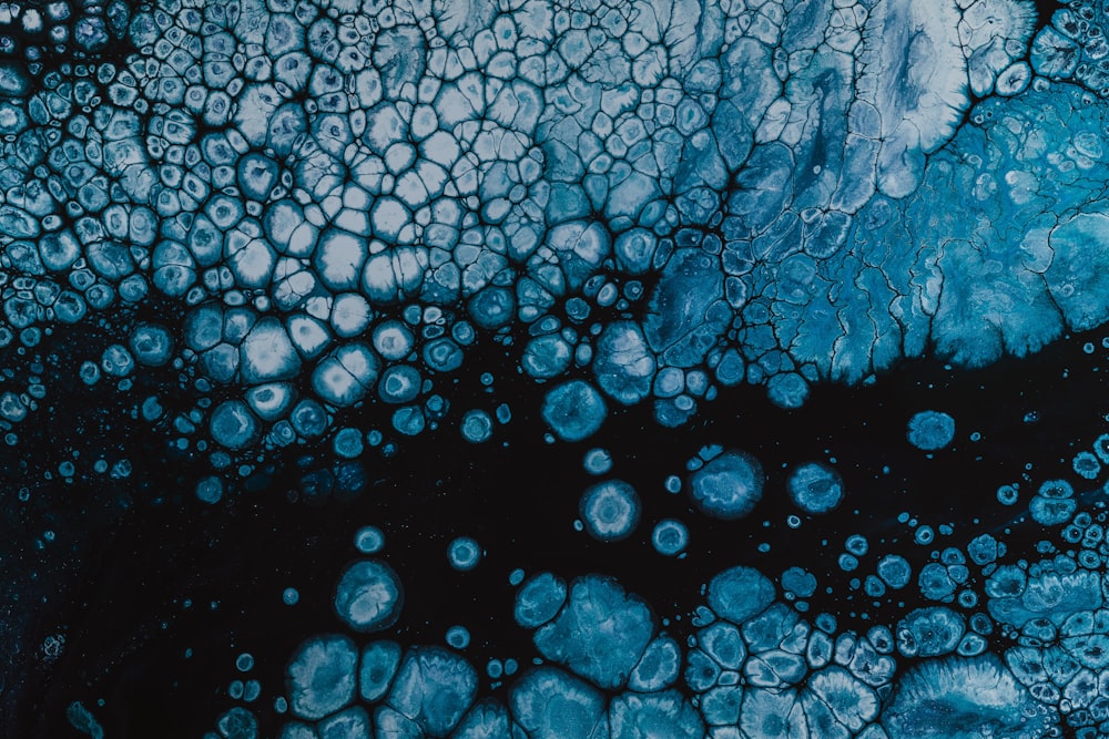 a blue and black abstract painting with bubbles