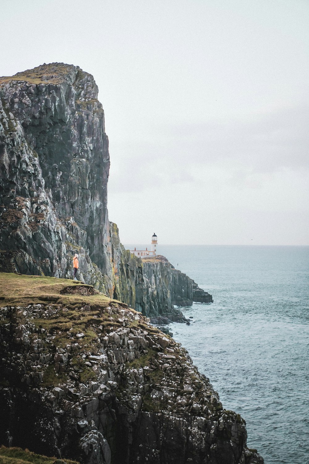 person standing on rocky mountain island during day