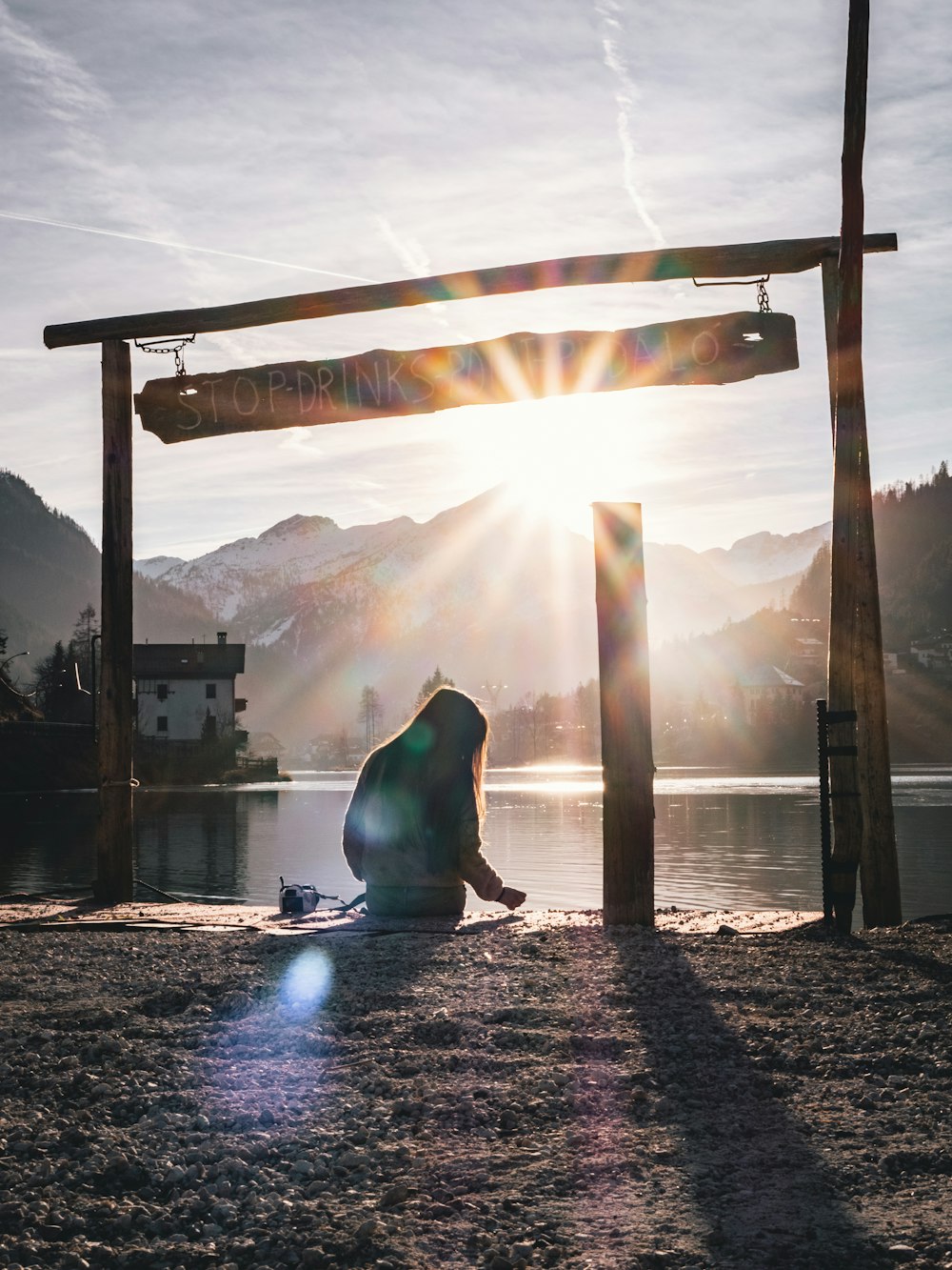 a person sitting on the ground in front of a body of water