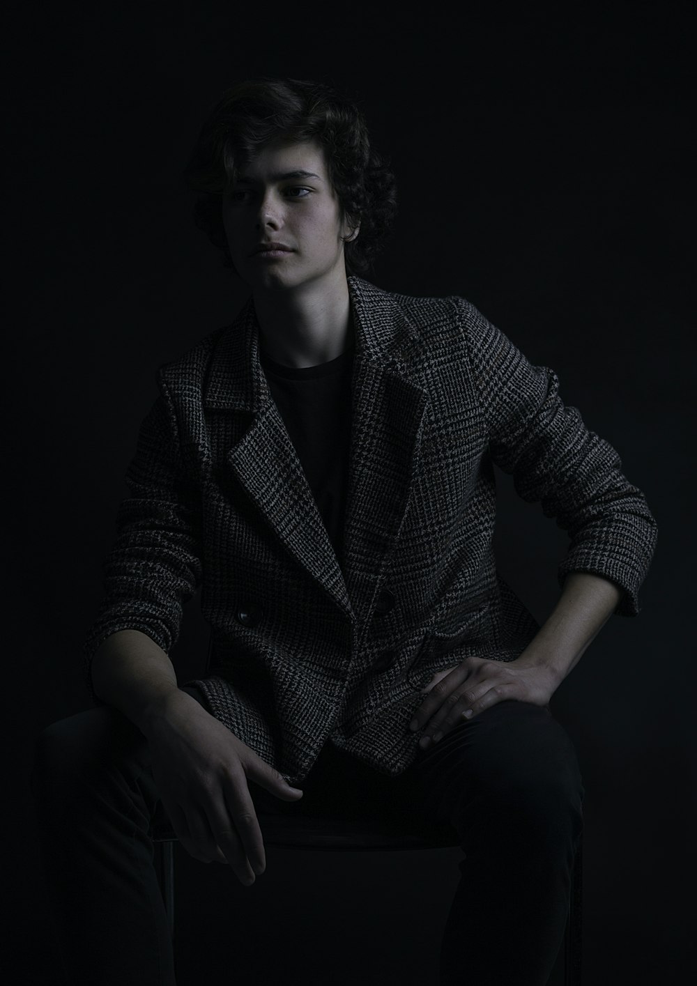 a man sitting on a chair in a dark room