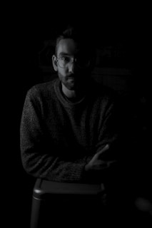 An intimate portrait from a documentary capturing a storyteller mid-narrative in a dimly lit room.