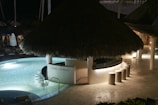 An elegant, secluded poolside lounge with plush seating and ambient lighting.