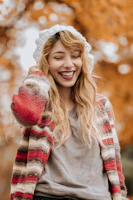 A customer wearing a chunky knit pullover, smiling outdoors on a crisp day.