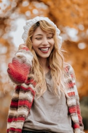 A cozy autumn outfit featuring a warm sweater and jeans on a smiling adult model.