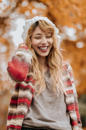 A customer wearing a chunky knit pullover, smiling outdoors on a crisp day.