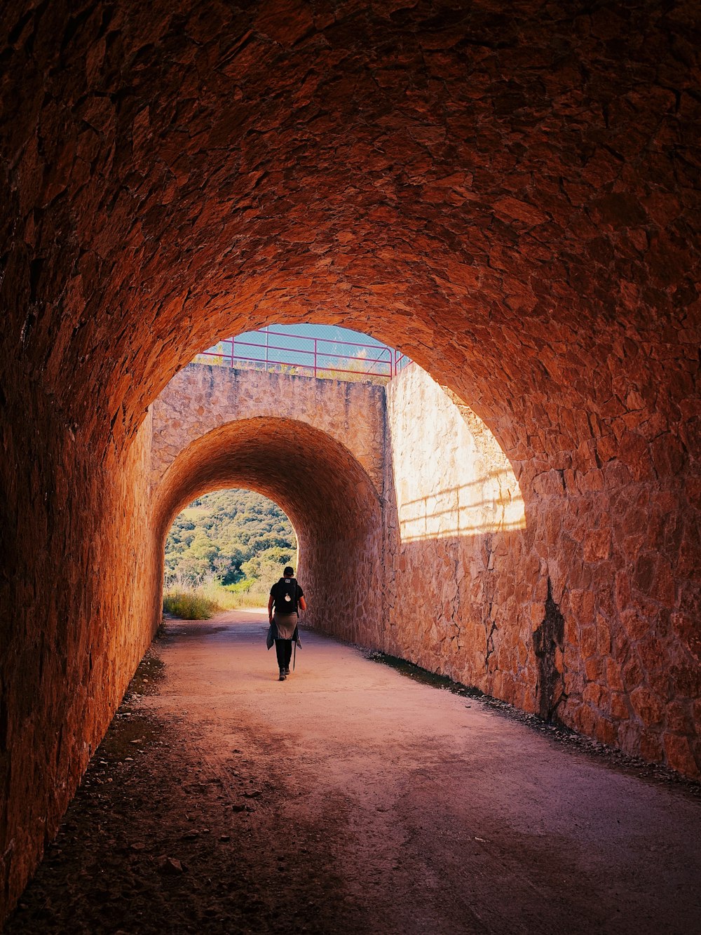 person walking on tunnel duringdaytime