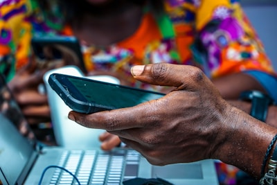 shallow focus photo of person holding black Android smartphone