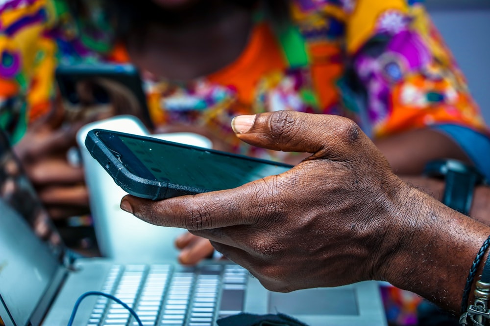 shallow focus photo of person holding black Android smartphone