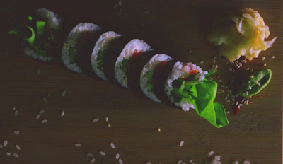 Elegant wooden sushi box presentation featuring colorful rolls with ginger and sauces.