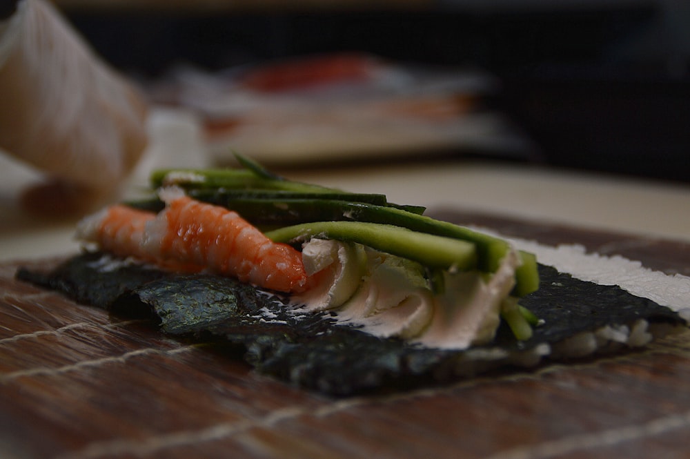 a piece of sushi on a wooden cutting board