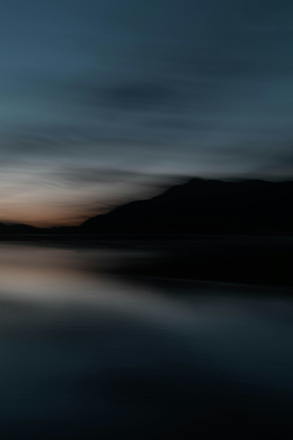 a large body of water with mountains in the background