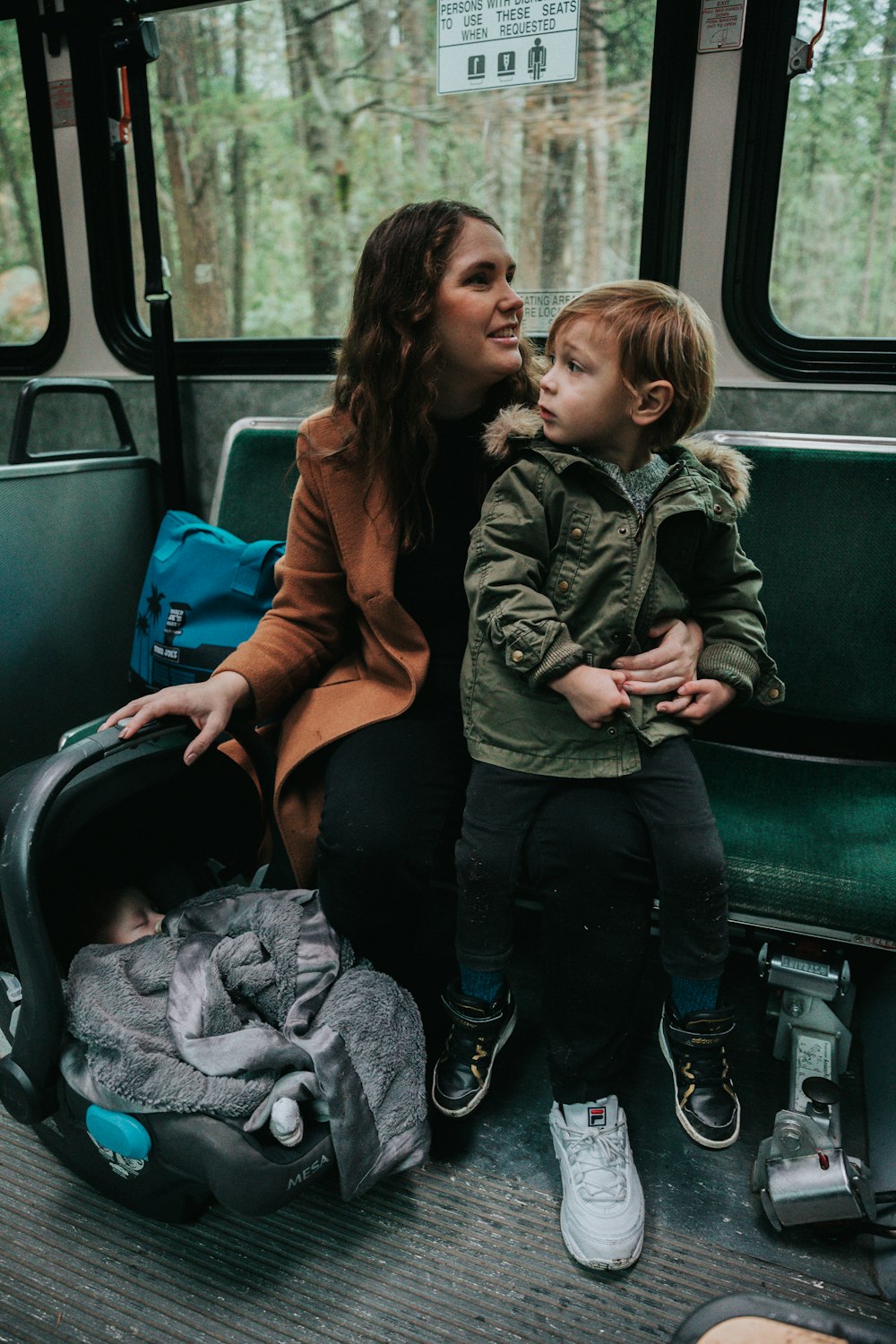 shallow focus photo of boy sitting on woman's lap