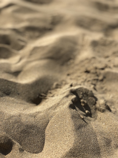 Close-up of sand-proof PicnicPro mat edges with grains of sand brushed off effortlessly