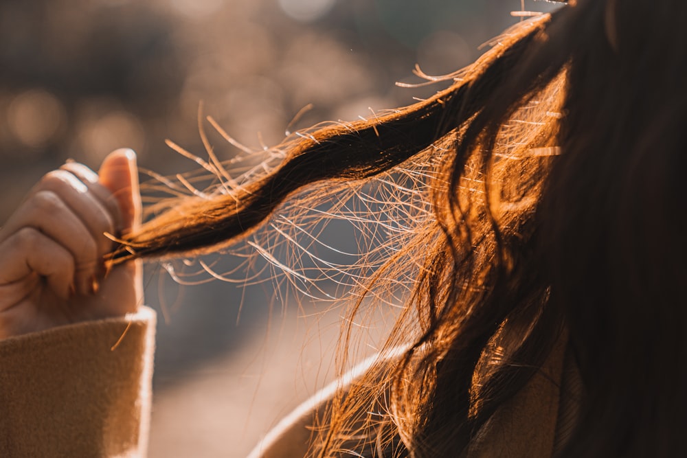 close-up photography of person holding her hair