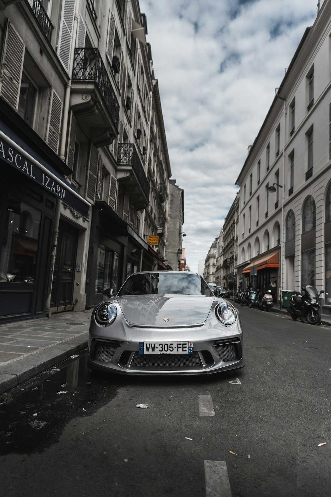 parked vehicle on road between buildings