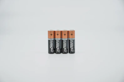 A stack of durable batteries glowing softly with amber highlights on a smooth surface.