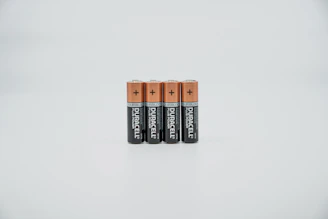 A stack of durable batteries glowing softly with amber highlights on a smooth surface.