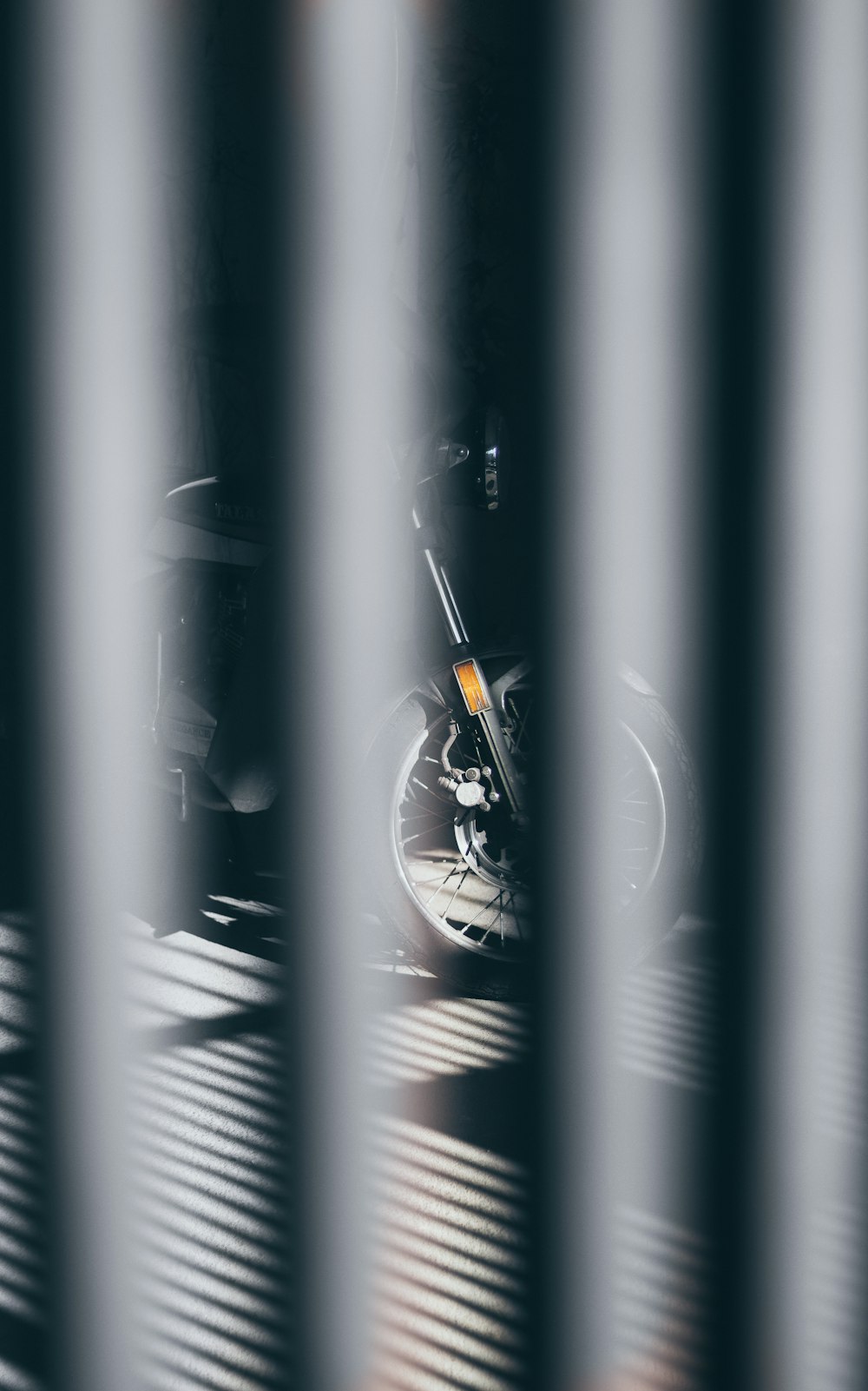 a motorcycle is seen through the bars of a window