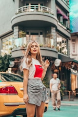 selective focus photography of woman standing on the side of street