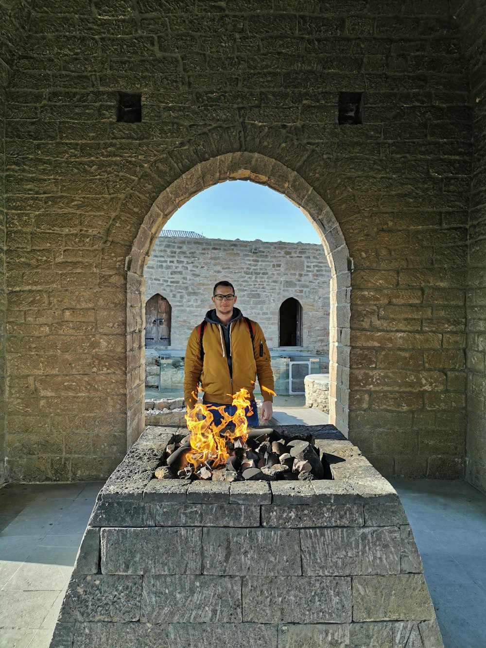 man standing in front of fire pit during daytime