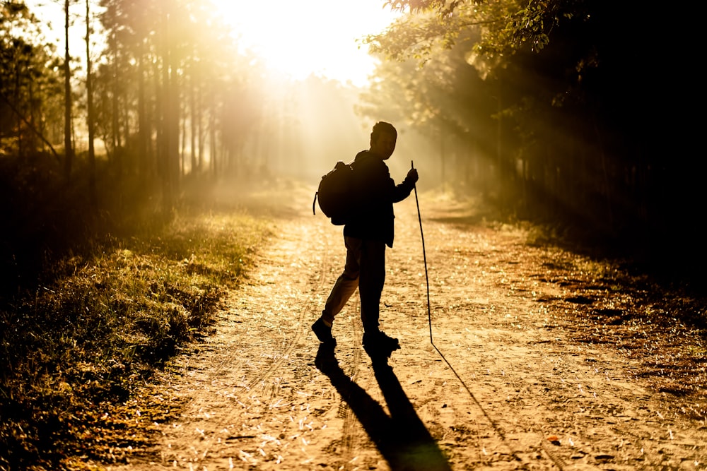 silhouette of man holding stick