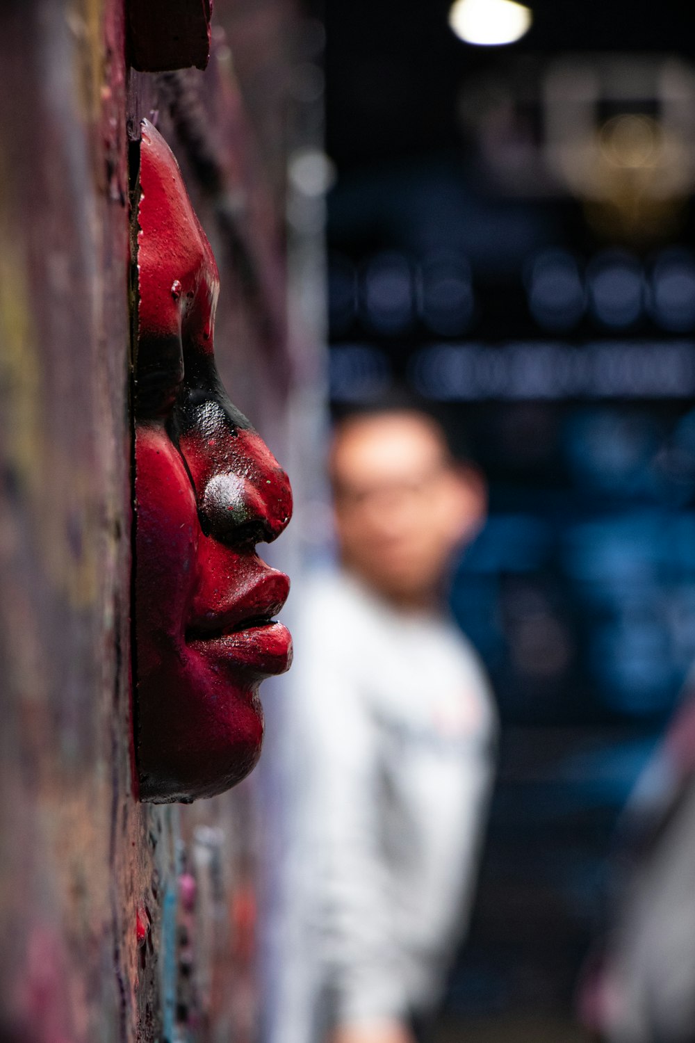a person with red paint on their face behind a wall