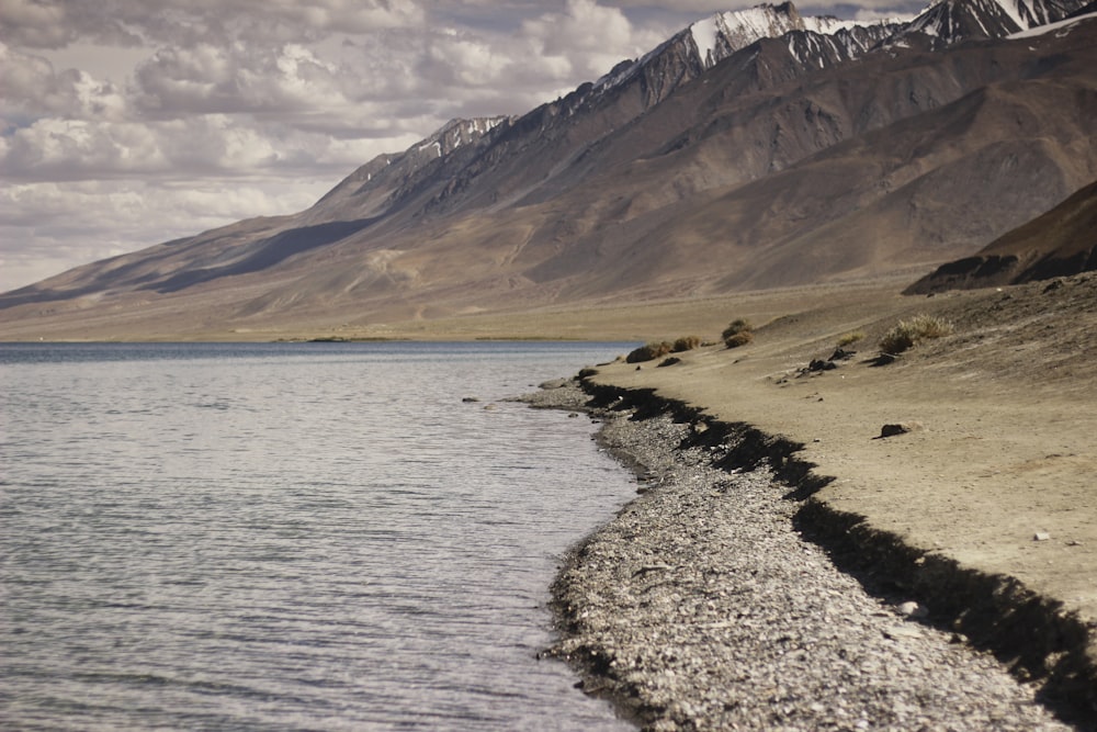 brown rock formation near body of water