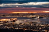 aerial view of lighted city buildings near river during golden hour