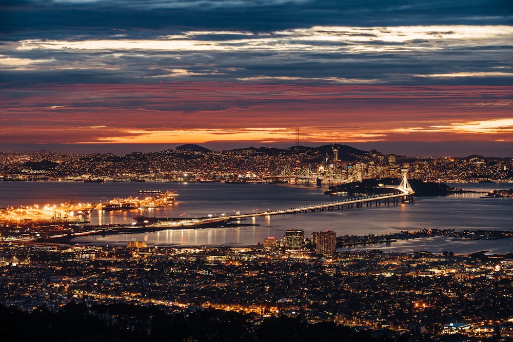 vista aérea de edifícios iluminados da cidade perto do rio durante a hora de ouro