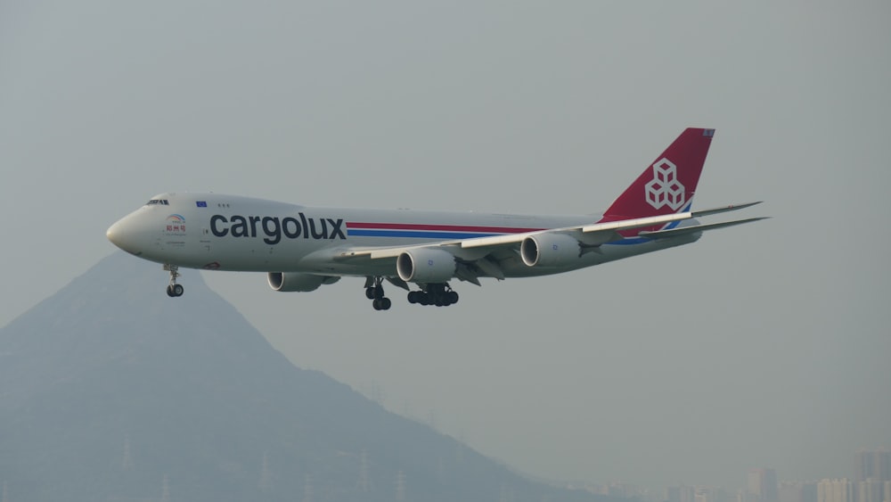 white, red, and blue Cargolux airplane in flight