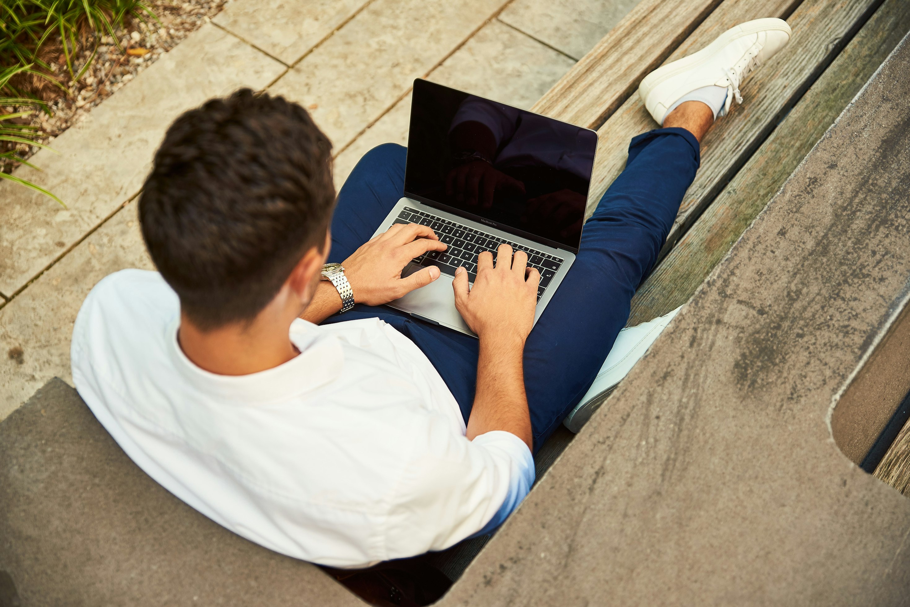 Digital Nomad working outdoors on bench