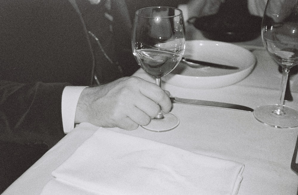 man touching near empty wineglass