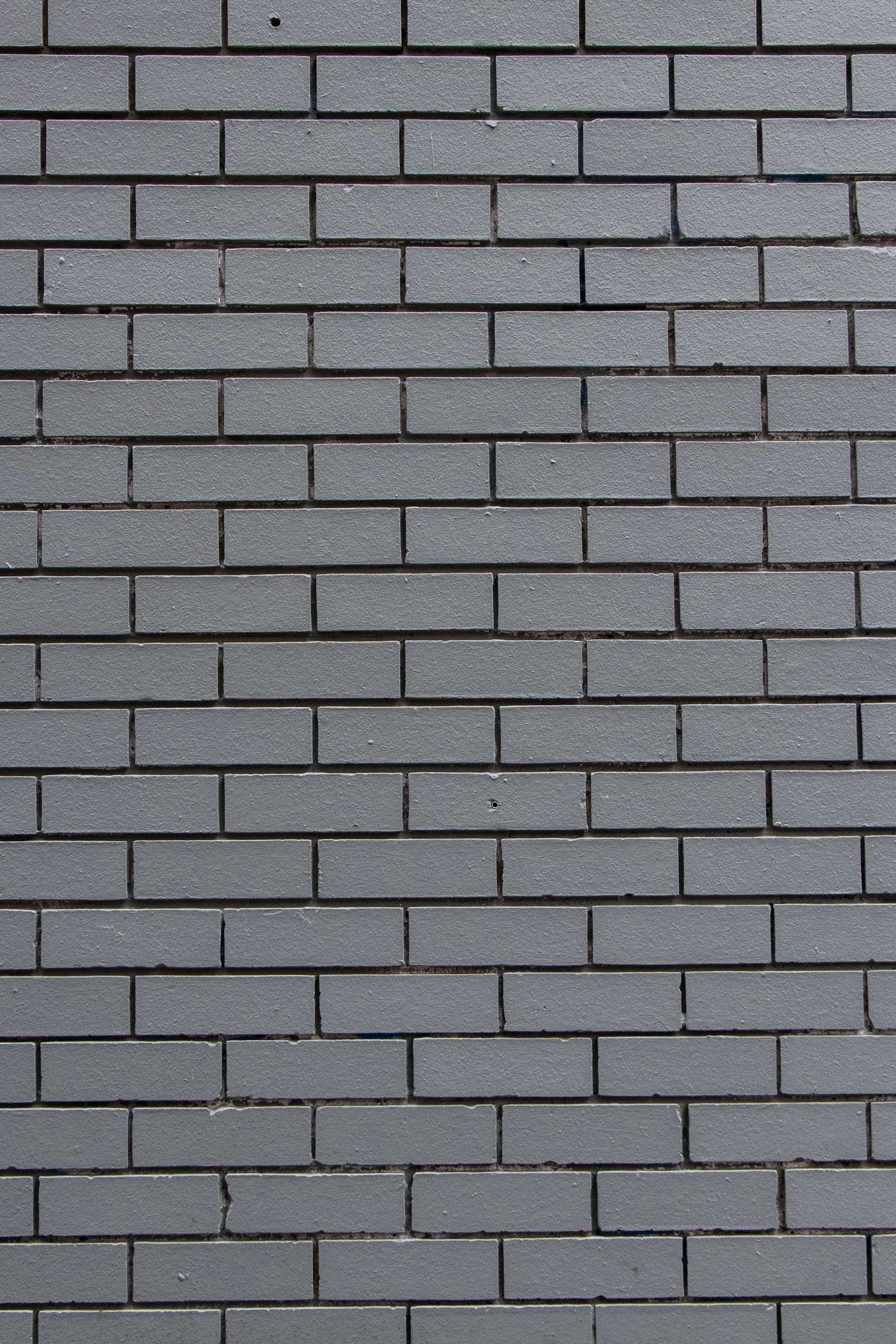 a red fire hydrant sitting on the side of a brick wall